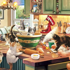 Op de afbeelding: Een keukenscène met een groep kittens die spelen op een aanrecht dat bedekt is met bloem en eieren. Op de achtergrond staat een rode keukenmachine, samen met een keukenweegschaal en andere keukengerei.