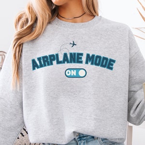 May include: Gray sweatshirt with a blue graphic that says "Airplane Mode On" with a stylized airplane and an on/off switch.