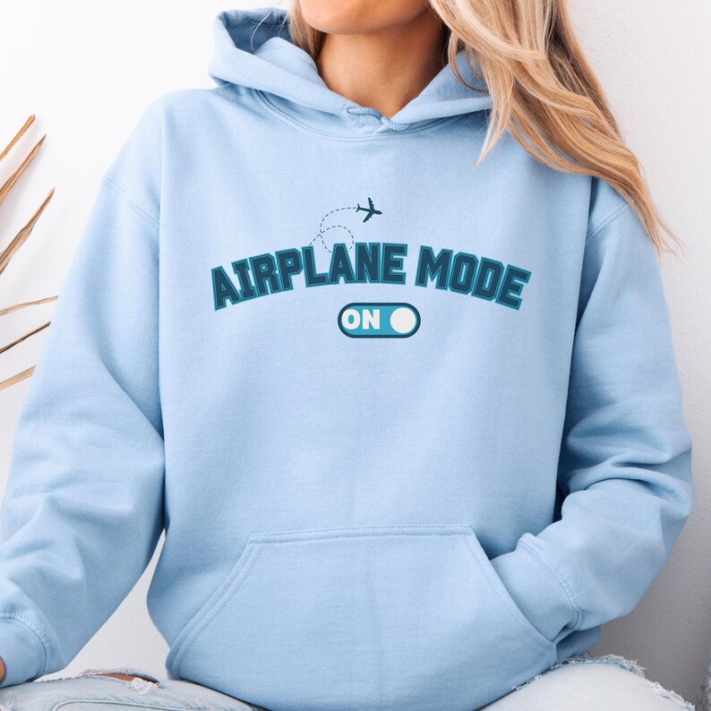 May include: A light blue hoodie with the text "Airplane Mode On" in blue and white lettering. A small airplane icon is above the text.