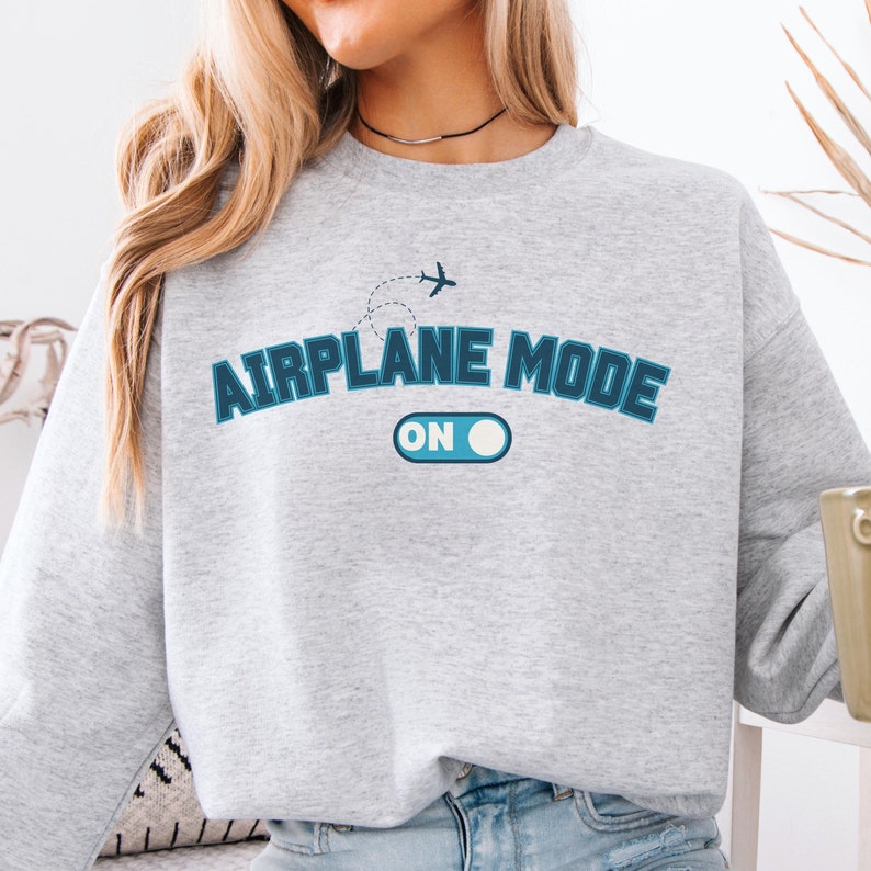 May include: Gray sweatshirt with a blue graphic that says "Airplane Mode On" with a stylized airplane and an on/off switch.