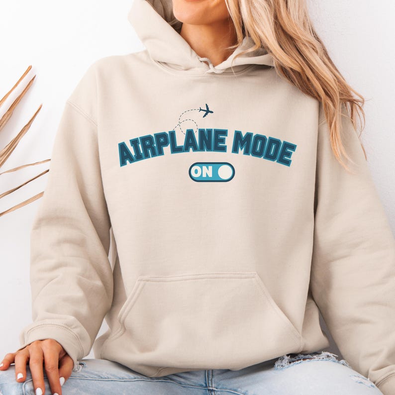 May include: A beige hoodie with a blue graphic that says "Airplane Mode On" with a stylized airplane and a toggle switch.