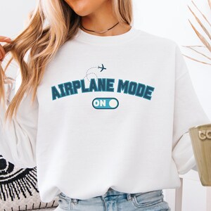 May include: White sweatshirt with blue text that reads "Airplane Mode On" with a graphic of an airplane and a toggle switch.