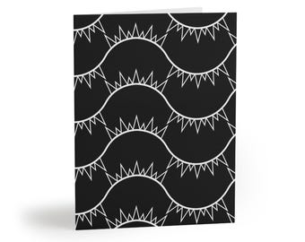 May include: A folded greeting card featuring a repeating pattern of white wavy lines on a solid black background. Each wave is topped with a series of sharp, triangular spikes, creating a consistent geometric design across the entire surface.
