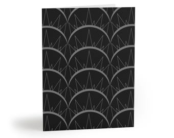 May include: A folded greeting card featuring a repeating pattern of dark gray semicircles on a black background. Each semicircle contains a series of thin, pointed triangular lines that extend upward, creating a geometric, crown-like motif across the surface.
