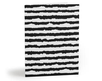 May include: A folded greeting card featuring a repeating pattern of horizontal black stripes against a white background. The stripes have a textured, hand-painted appearance with irregular, rough edges that create a distinct contrast across the surface.