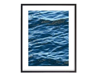May include: A framed photograph of a close-up of blue ocean water with ripples and waves.