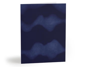 May include: A folded greeting card featuring a dark navy blue background with two horizontal, wavy, lighter blue bands that have a soft, blurred, and cloud-like texture. The design is centered on the front cover of the rectangular card.