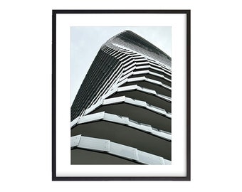 May include: A black and white photograph of a modern building with a unique curved design. The building has a series of horizontal lines that create a geometric pattern.