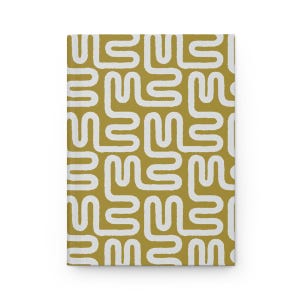 Puede incluir: Un cuaderno de tapa dura con un fondo amarillo mostaza y un dise&ntilde;o abstracto blanco repetido. El dise&ntilde;o consiste en formas redondeadas interconectadas, creando un patr&oacute;n texturizado en la cubierta.