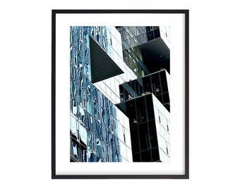 May include: A modern building with a geometric design, featuring a mix of black and blue glass panels. The building has a unique, angular shape, creating a sense of depth and dimension.