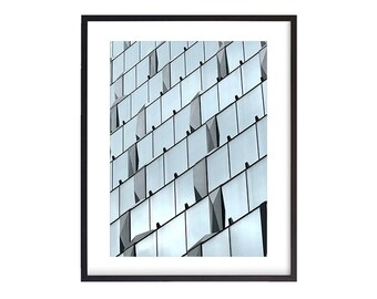 May include: A close-up of a modern building with a geometric pattern of windows. The windows are made of glass and have a light blue tint. The building is made of concrete and has a sleek, modern design.
