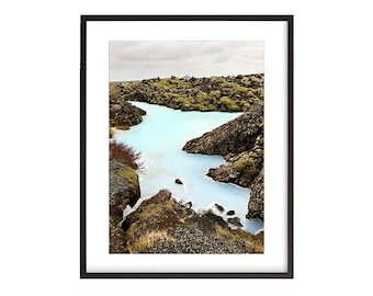 May include: A blue lagoon surrounded by moss-covered rocks in a scenic landscape.