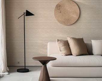 May include: A modern living room scene featuring a dark wood side table with a conical base and a round top. A black floor lamp with a triangular shade stands nearby. A beige sofa with pillows and a circular wall art piece complete the decor.