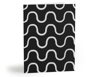 May include: A folded greeting card featuring a repeating pattern of horizontal, light gray wavy lines set against a solid black background. The design consists of multiple stacked rows of consistent, hand-drawn style curves across the front cover.
