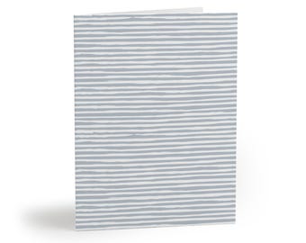 May include: A folded greeting card featuring a pattern of horizontal, hand-drawn style stripes in light gray against a white background. The card is oriented vertically, showing the front cover with a consistent, repeating linear design.