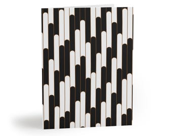 May include: A folded greeting card featuring a repeating pattern of vertical, rounded-end bars in alternating black and off-white colors. Each bar is outlined with a thin, metallic copper-colored line, creating a structured, geometric design.