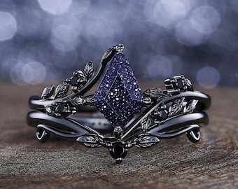 May include: A black ring set with a blue gemstone and black accents. The ring features a delicate, leafy design.