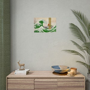 May include: A digital art print of a green wave crashing over a red figure sitting on a wooden platform. The wave is reminiscent of the famous Japanese woodblock print "The Great Wave off Kanagawa" by Katsushika Hokusai.
