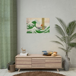 May include: A wood framed print of a large wave with a small figure standing on a platform in the distance. The print is hanging on a light beige wall above a wooden cabinet with a deer figurine and books on top.