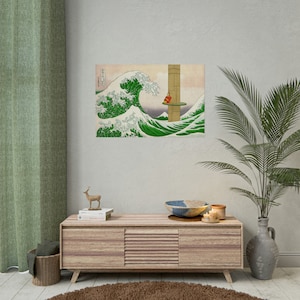 May include: A wood framed print of a green wave crashing with a red figure standing on a platform in the distance. The print is hanging on a light beige wall above a light brown wooden cabinet with a deer figurine and books on top.