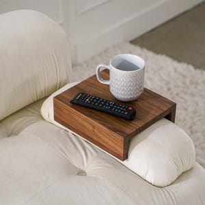 White oak sofa side table designed to rest securely on the arm of a couch or sofa provides a stable surface for holding drinks snacks remotes or phones this wood armrest tray table also functions as a compact side table ideal for small living rooms apartments and minimalist spaces