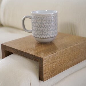 Sofa arm tray table made from solid white oak fits over the arm of your couch to create a convenient and sturdy surface for daily use perfect for holding snacks coffee remotes or a phone this wood couch side table adds function and style to compact living spaces with a clean natural finish