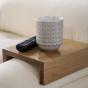 White oak couch arm tray table handcrafted for functionality and style serves as a sofa armrest table or wood side table designed for small spaces it provides a stable surface for drinks or snacks fits securely on most sofa arms and enhances the look of any modern or rustic interior