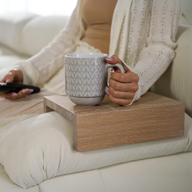 White oak sofa side table designed to rest securely on the arm of a couch or sofa provides a stable surface for holding drinks snacks remotes or phones this wood armrest tray table also functions as a compact side table ideal for small living rooms apartments and minimalist spaces