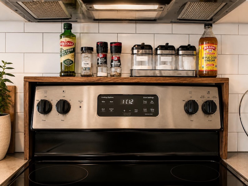 Custom walnut kitchen storage shelf designed to sit above the stove back panel and provide space for spices oils vinegar jars and small decor a practical wooden organizer for a cleaner more organized cooking area
