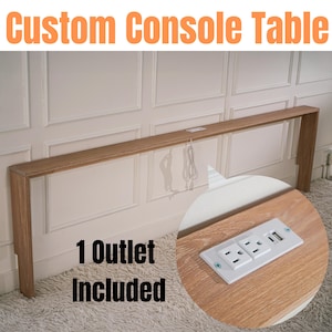 Puede incluir: Una mesa consola personalizada de madera con una toma de corriente integrada. La mesa está montada en una pared y tiene un acabado en madera clara. El texto "1 Outlet Included" es visible en la imagen.