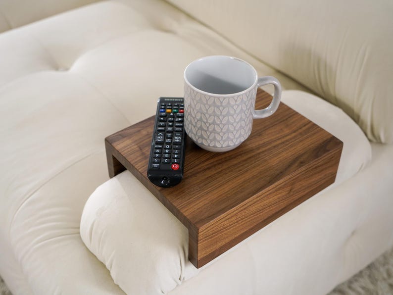 Sofa arm table crafted from white oak fits snugly over the couch armrest creating a practical flat surface for holding everyday items such as drinks snacks or remotes this compact wood side table is ideal for small apartments or minimalist homes offering style and convenience in one piece
