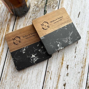 Pu&ograve; includere: Due sottobicchieri quadrati in legno con un design in marmo bianco e nero. La met&agrave; superiore di ogni sottobicchiere &egrave; in legno con il testo "M & K" in una ghirlanda, "Mellisa & Kishan" e "September 9, 2023" inciso.
