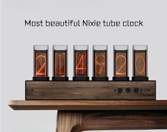 May include: A Nixie tube clock showing the time 2:14:20. The clock features six glass tubes with illuminated orange digits, mounted on a dark wooden base. The text "Most beautiful Nixie tube clock" is above the clock.