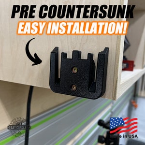 May include: A black plastic wall mount with pre-countersunk holes for easy installation. The mount is attached to a light wood surface. The text "PRE COUNTERSUNK EASY INSTALLATION!" is visible in the image. "Made in USA" is also visible in the image.