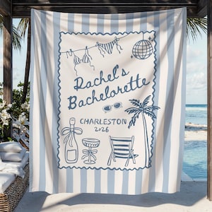May include: A white and blue striped beach towel with a blue illustration. The illustration includes the text "Rachel's Bachelorette Charleston 2026", a bikini, sunglasses, a disco ball, a palm tree, a champagne bottle, a cocktail glass, and a beach chair.