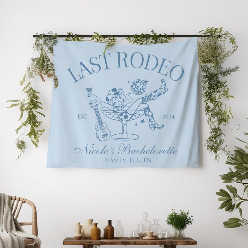 Pu&ograve; includere: Arazzo azzurro chiaro con una cowgirl con un cappello da cowboy seduta in un bicchiere da martini. Il testo "Last Rodeo" &egrave; in alto, con "Est. 2024" sotto. Il testo "Nicole's Bachelorette Nashville, TN" &egrave; in basso.