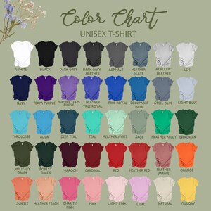Puede incluir: Carta de colores que muestra 28 colores diferentes de camisetas unisex. Los colores est&aacute;n dispuestos en filas y columnas, con los nombres de cada color debajo de la camiseta correspondiente.