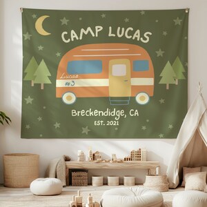Puede incluir: Un tapiz verde con una caravana de dibujos animados, estrellas y &aacute;rboles. El texto en el tapiz dice "Camp Lucas", "Lucas #3", "Breckenridge, CA" y "Est. 2021".