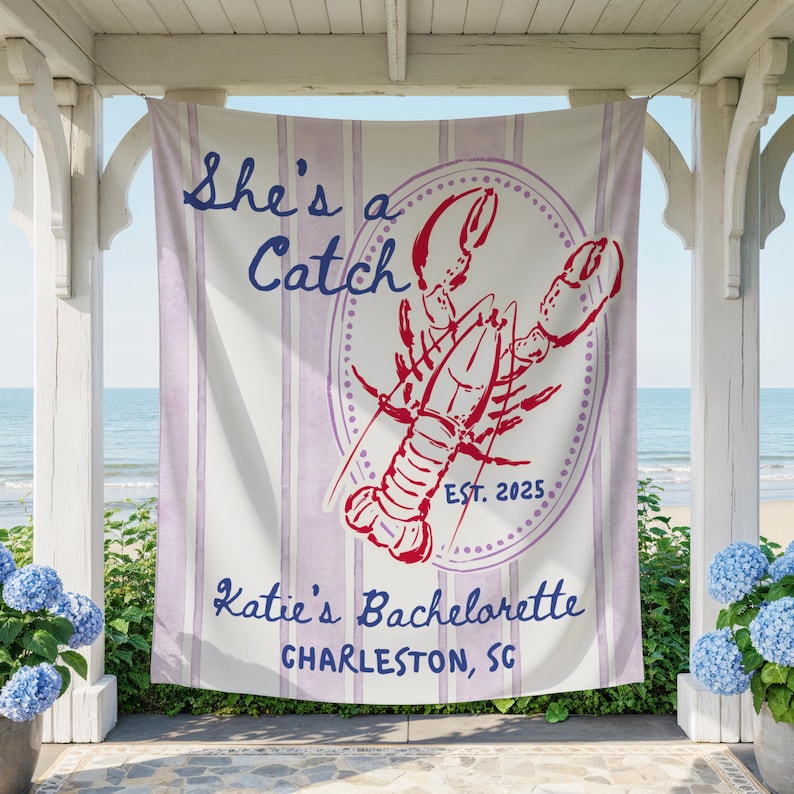 May include: A white and lavender striped banner with the text "She's a Catch" and "Katie's Bachelorette Charleston, SC". A red lobster graphic is in the center, with "EST. 2025". The banner is hanging outdoors.