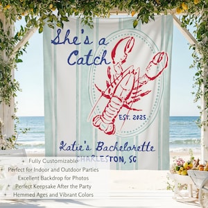 May include: A white backdrop with vertical light blue stripes and the text "She's a Catch" in blue script. A red lobster illustration is centered, with "EST. 2025" below. "Katie's Bachelorette" and "CHARLESTON, SC" are also displayed.
