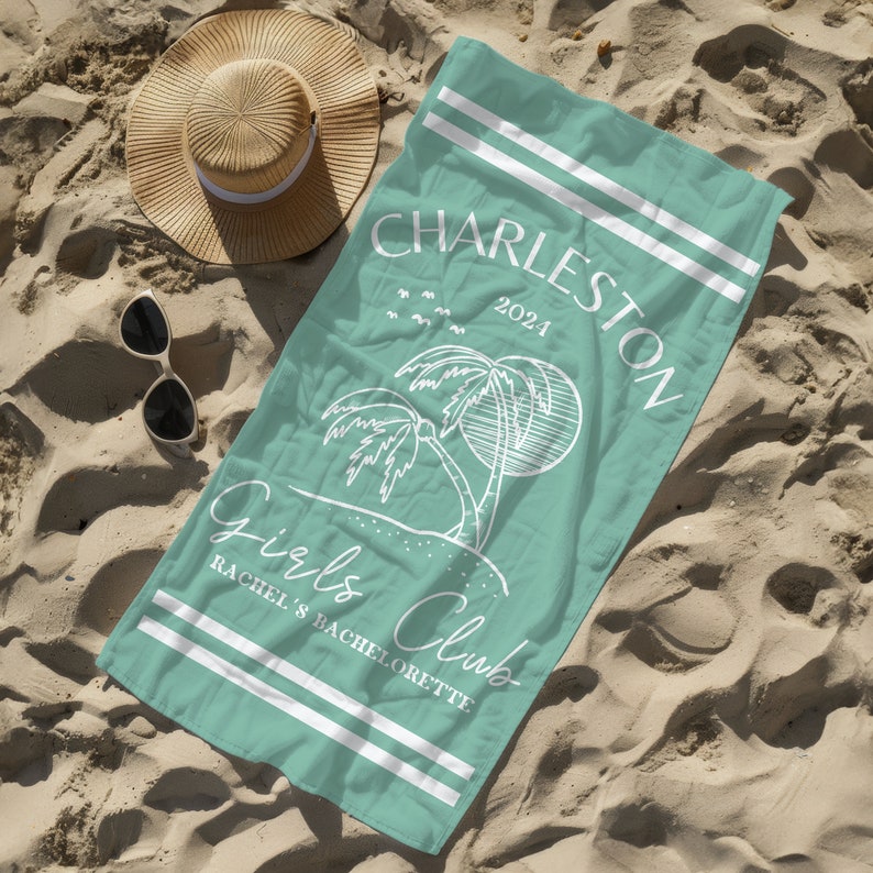 Puede incluir: Una toalla de playa turquesa con rayas blancas y el texto "Charleston 2021 Girls Club Rachel's Bachelorette" impreso en ella. La toalla presenta un contorno blanco de palmeras y un sol.