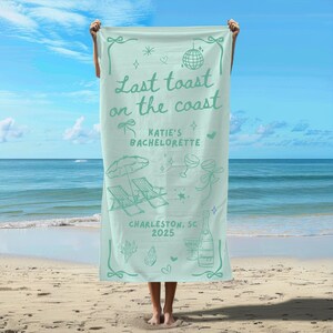 May include: A light blue beach towel with the text "Last toast on the coast" and "Katie's Bachelorette" in a green font. The towel also features a beach scene with palm trees, beach chairs, and a cocktail glass. The text "Charleston, SC 2025" is printed at the bottom of the towel.