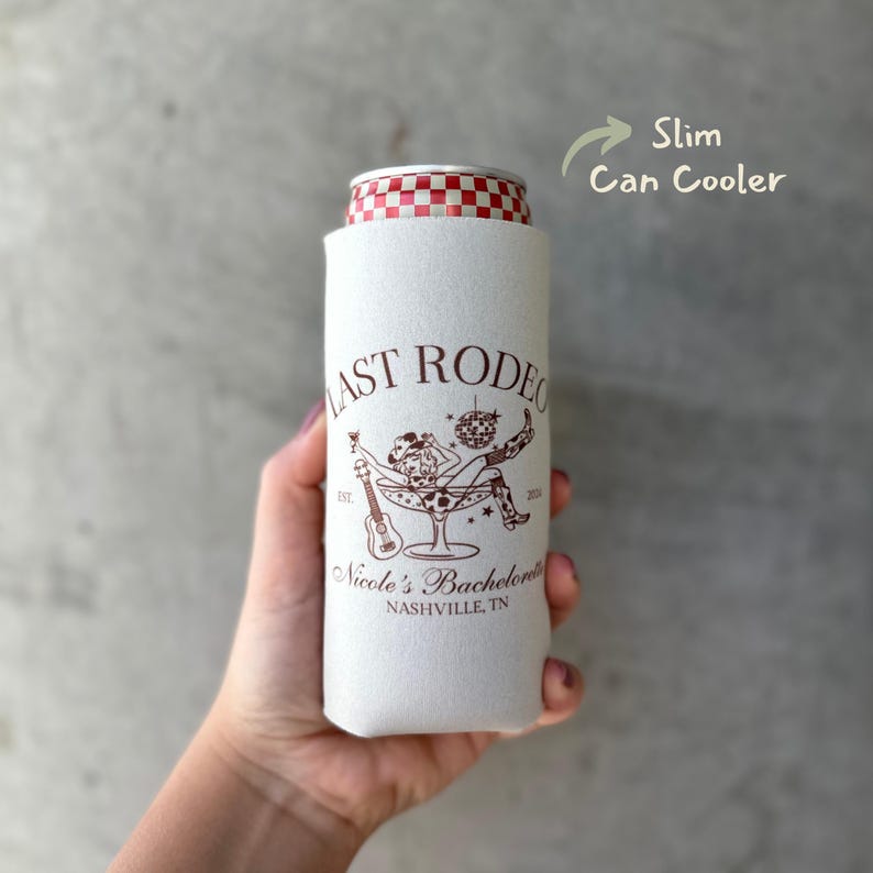 Pu&ograve; includere: Frigorifero per lattine bianco sottile con una grafica marrone di una donna con un cappello da cowboy seduta in un bicchiere da martini. Il testo "Last Rodeo" &egrave; sopra la grafica e "Nicole's Bachelorette Nashville, TN" &egrave; sotto la grafica.