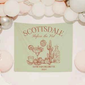 Puede incluir: Un tapiz verde claro con la inscripci&oacute;n "SCOTTSDALE Before the Veil" en marr&oacute;n rojizo. Presenta ilustraciones de una margarita, un cactus, una botella de tequila y fresas. El texto "KATIE'S BACHELORETTE 2024" est&aacute; en la parte inferior.