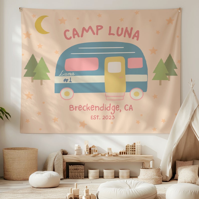 Puede incluir: Un tapiz de color melocot&oacute;n con una ilustraci&oacute;n de una autocaravana azul. La autocaravana tiene un interior rosa y amarillo y el texto "Camp Luna" en una fuente retro. El texto "Breckenridge, CA EST. 2023" est&aacute; debajo de la autocaravana.