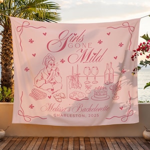 May include: A pale pink tapestry featuring the text "Girls Gone Mild" and "Melissa's Bachelorette Charleston, 2025". The design includes illustrations of a woman, food, drinks, and decorative elements. The tapestry is displayed outdoors.