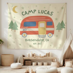 Puede incluir: Un tapiz de color amarillo y crema con una ilustraci&oacute;n de una caravana roja. El texto "Camp Lucas" est&aacute; en la parte superior del tapiz. La caravana tiene el texto "Lucas #3" en el lateral. El texto "Breckenridge, CA EST. 2021" est&aacute; debajo de la caravana.