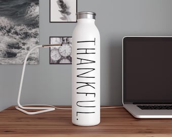 Botella de agua delgada con mensaje positivo: agradecido.