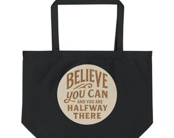 Könnte beinhalten: Schwarze Tragetasche mit einem kreisförmigen Design mit dem Text "BELIEVE you CAN AND YOU ARE HALFWAY THERE" in braunen Buchstaben. Die Tasche hat eine rechteckige Form mit einem Griff.