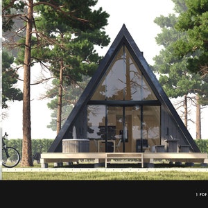 K&ouml;nnte beinhalten: Ein schwarzes A-f&ouml;rmiges Haus mit gro&szlig;en Fenstern und einer Holzterrasse. Das Haus ist von Kiefern umgeben und hat einen Whirlpool auf der Terrasse. Der Text "864 SF" ist in der oberen linken Ecke des Bildes sichtbar.